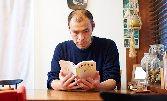 「ヨチヨチ父 -とまどう日々-」を読むヨシタケさんの写真