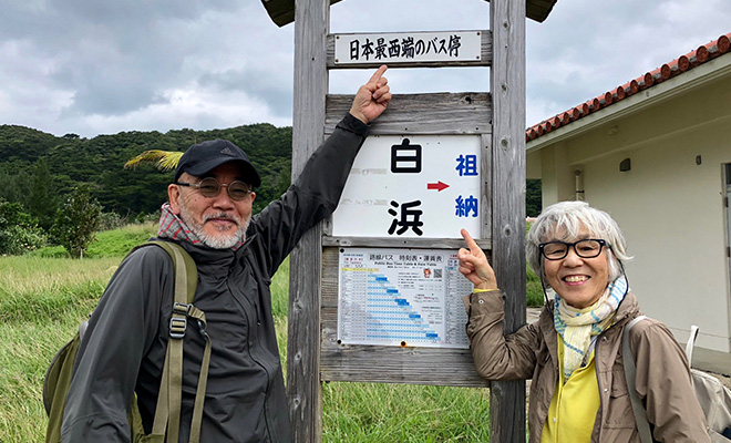 沖縄県西表島の日本最西端のバス停前の林多佳子さんと行雄さん
