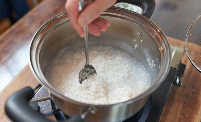 鍋のふたをあけてスプーンで鍋底をすくう