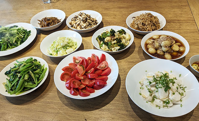 テーブルの上に、シンプルな野菜炒めや煮物などの手作り料理が並んでいる