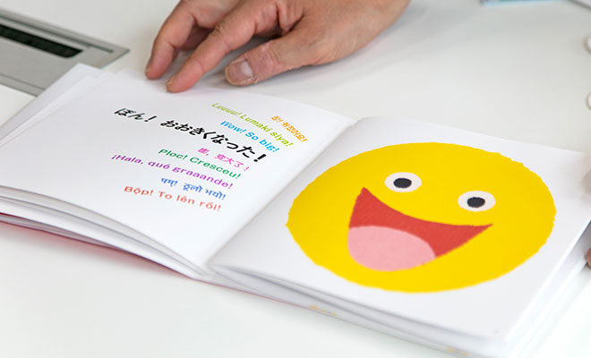 『いち にの さん!』の絵本をスギヤマさんが開いて「ぼん!おおきくなった!」というページを見せているシーン