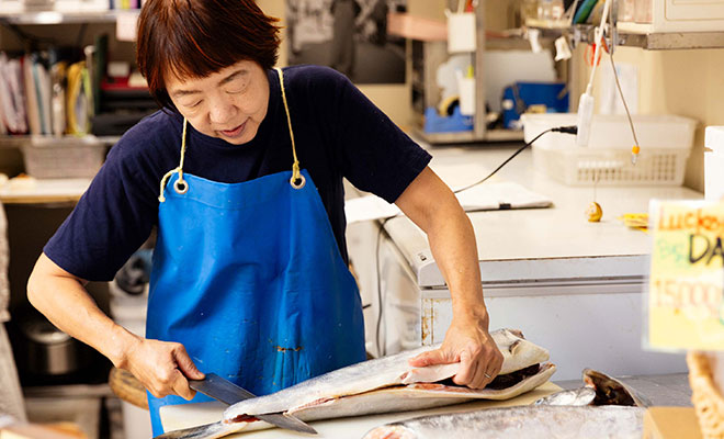 鮭をフィレに切る佐藤さん