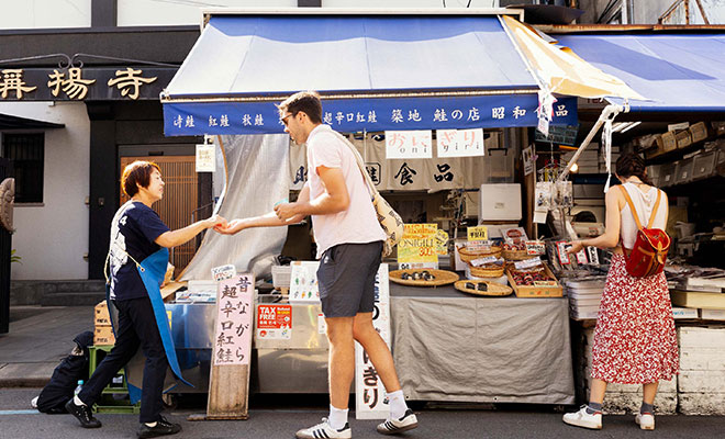 海外からの旅行者におにぎりを売る佐藤さん