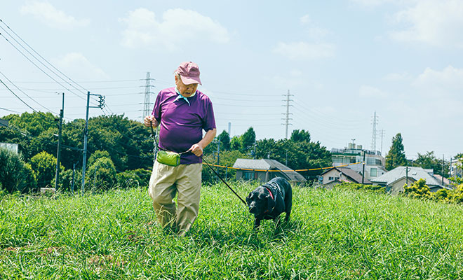 黒い大型犬のヴァートンと公園を散歩するまさるさん