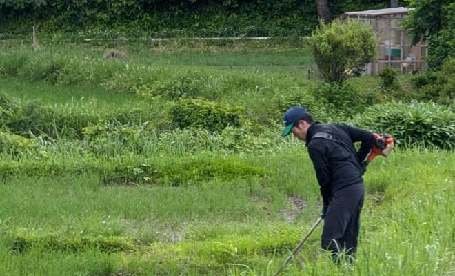 草刈りなどの農作業を行うようす