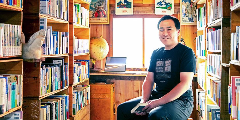 「冒険研究所書店」の店内でイスに座っている荻田泰永さん