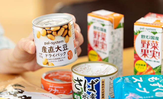 大豆ドライパック缶を持った今泉さんの手