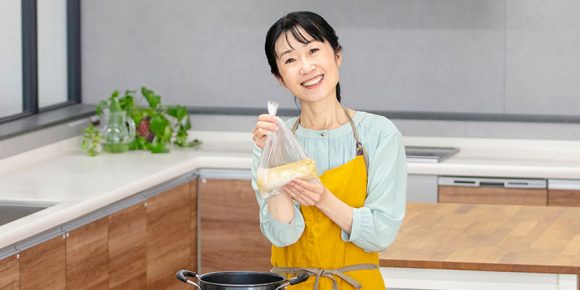 防災食のボイル調理をするために鍋の前に立って微笑む今泉マユ子さん