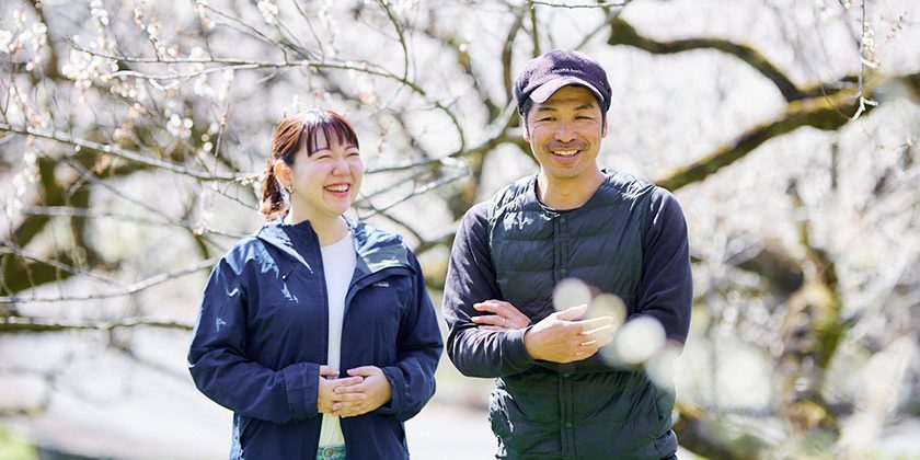 満開の梅畑で会話する今井真実さんと長谷川壮也さん