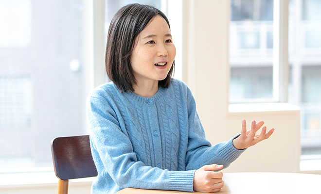 インタビューに笑顔で答える岡根谷さんの画像