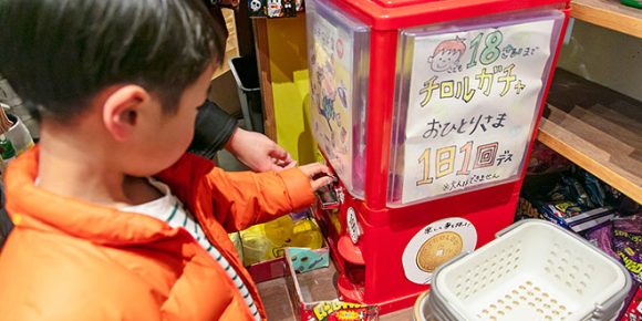 店内のガチャガチャを回す子どものようす