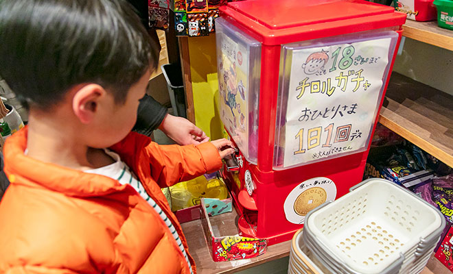 店内のガチャガチャを回す子どものようす