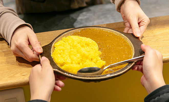 注文したカレーを受け取る子どもの手元画像