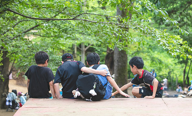 すべり台の上で話をする男の子たちの画像